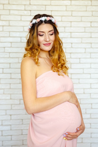 長い巻き毛を持つ若い幸せな笑顔の赤毛の女の子の肖像画