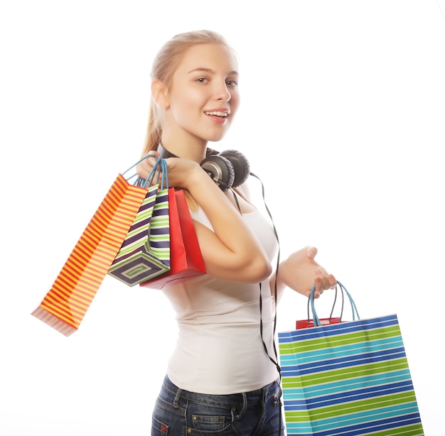 흰색 배경에 격리된 쇼핑백을 들고 웃고 있는 젊은 여성의 초상화