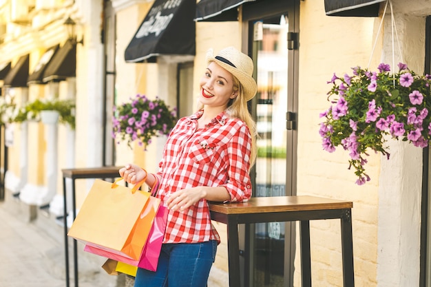 買い物袋を持つ若い幸せな笑顔の女性の肖像画