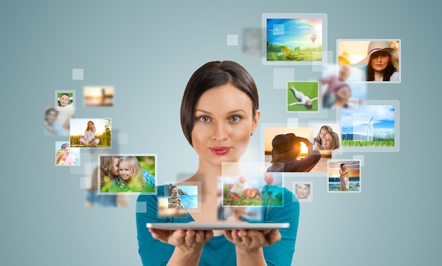 portrait of young happy woman sharing her photo and video files in social media resources using her modern tablet computer