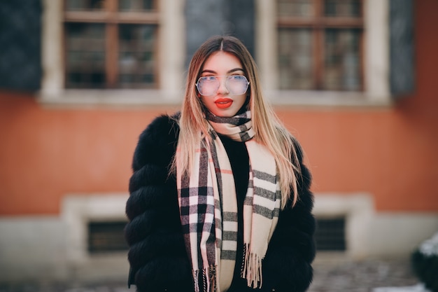 Portrait of young happy woman wearing winter clothes in french style, posing in streets