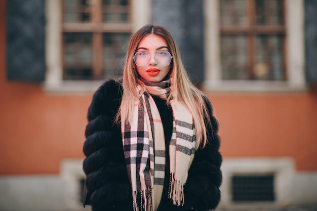 Portrait of young happy woman wearing winter clothes in french style, posing in streets