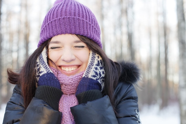 Portrait of a young happy woman in winter park