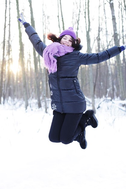 Portrait of a young happy woman in winter park