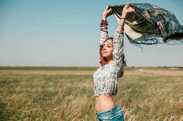 Portrait of a young hippie girl on a wheat field