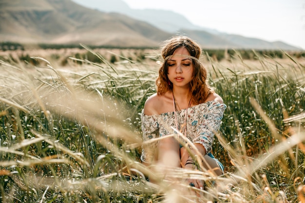 Portrait of a young hippie girl on a wheat field