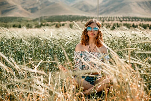 Ritratto di una giovane ragazza hippie su un campo di grano