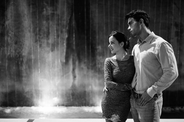 Portrait of young Hispanic couple exploring the city streets at night together