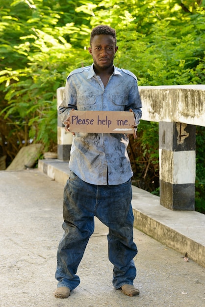 Portrait of young homeless African man on the bridge in the streets outdoors