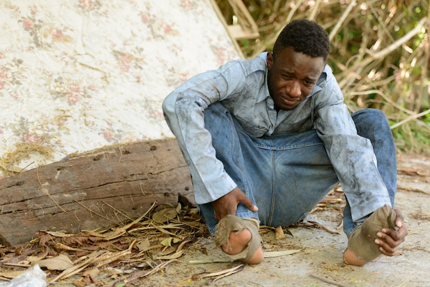 Portrait of young homeless African man in the streets outdoors