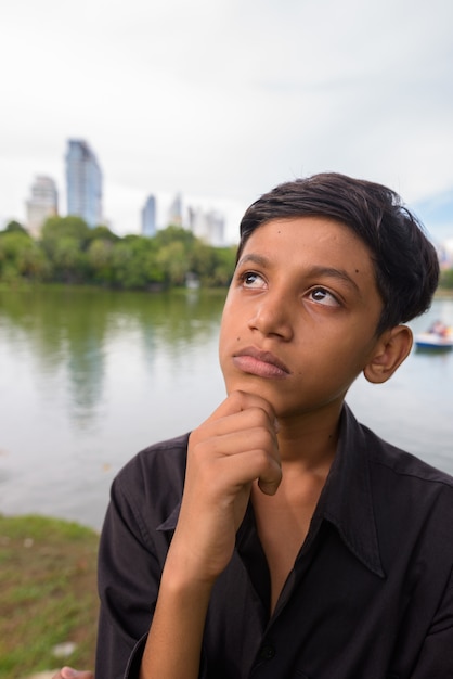 Portrait of young Indian boy relaxing at the park