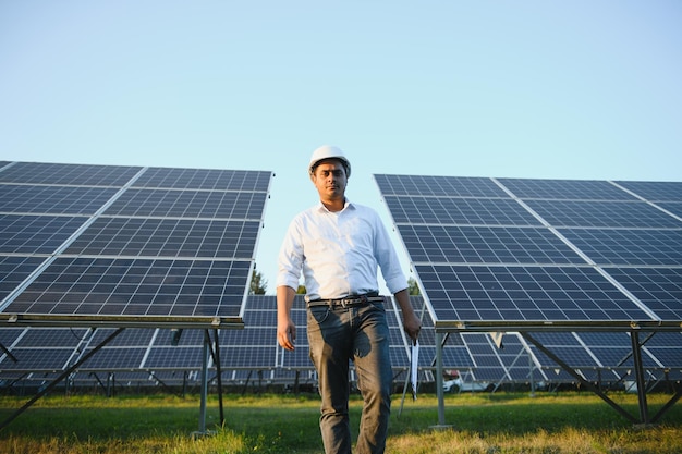 Portrait of a young Indian male engineer or architect at a solar panel farm The concept of clean energy