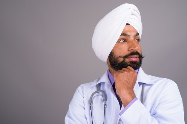 Portrait of young Indian Sikh man doctor thinking