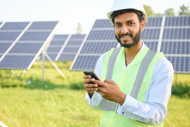 Портрет молодого индийского техника или менеджера в формальной одежде, стоящего с солнечной панелью, возобновляемых источников энергии, стоящего со скрещенными руками, копией пространства