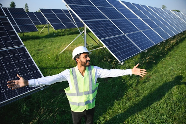 Portrait young indian technician or manager wearing formal cloths standing with solar panel renewable energy man standing crossed arm copy space