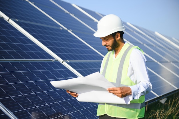 Portrait young indian technician or manager wearing formal cloths standing with solar panel