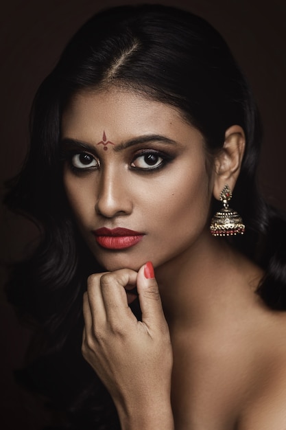 Premium Photo | Portrait of young indian woman with beautiful makeup and  hairstyle on brown wall
