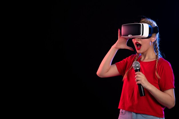 Portrait of young lady playing vr and singing on dark  music game visual