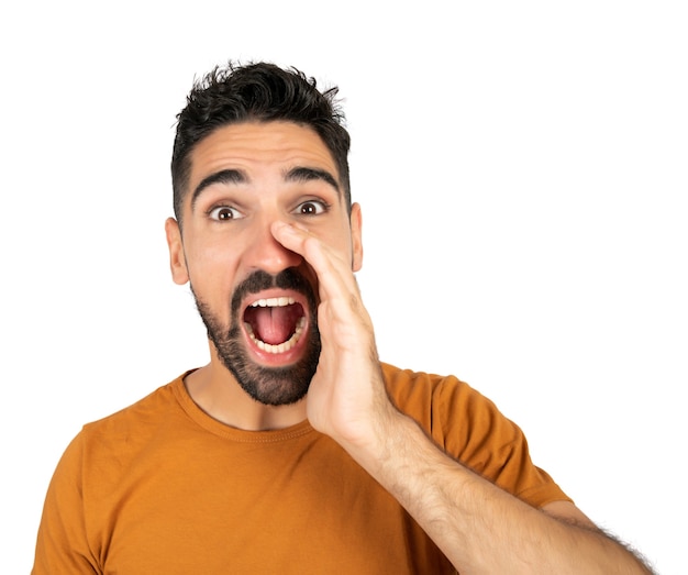 Portrait of young latin man shouting and screaming against white backgound