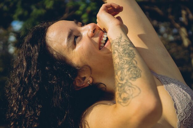 Portrait of a young latin woman smiling looking up at a park at sunset femininity vitality and sensitivity