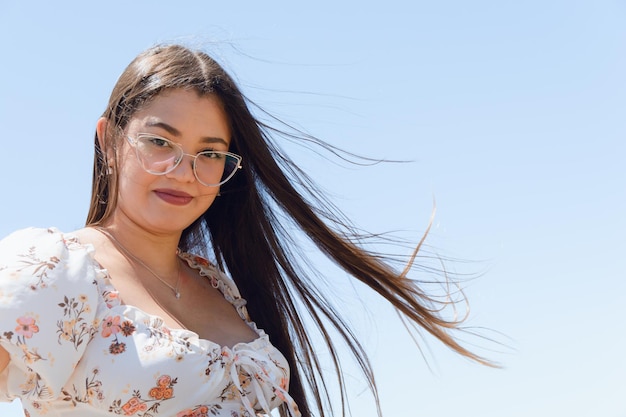 portrait of young latin woman with doubtful face looking at camera outdoors