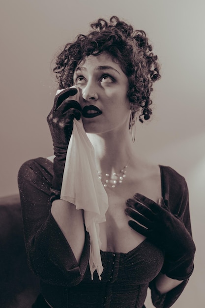 Portrait of a young latina woman crying with a handkerchief vintage black and white vertical photo