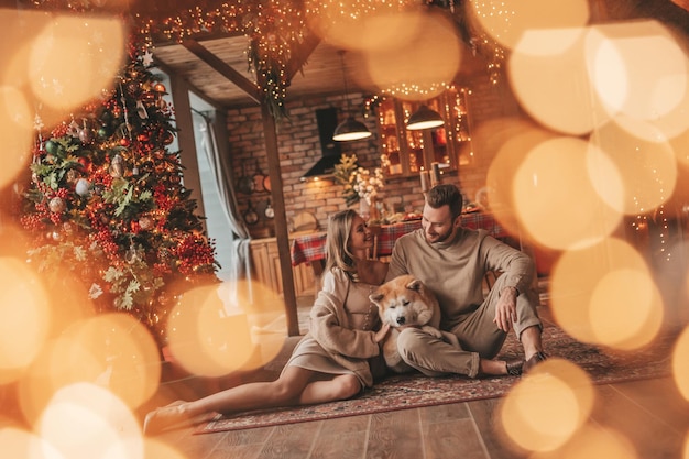 Foto ritratto di una giovane coppia adorabile che si abbraccia in casa la vigilia del 25 dicembre