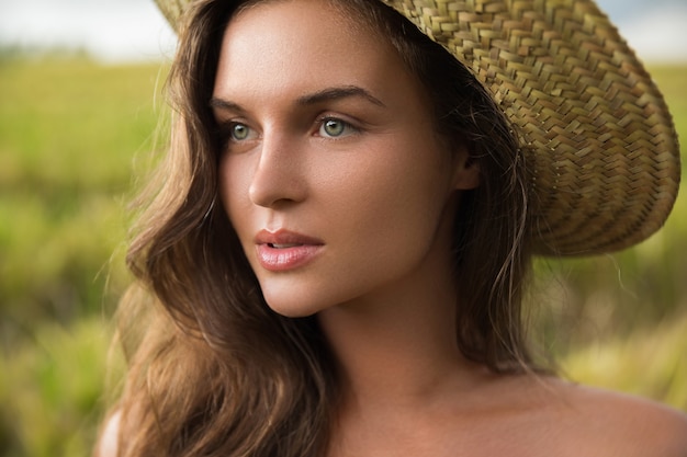 Portrait of young lovely woman wearing straw hat
