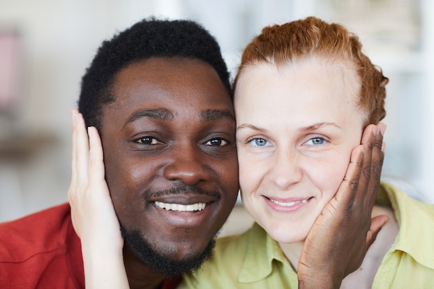 Portrait of young loving multiracial couple and smiling