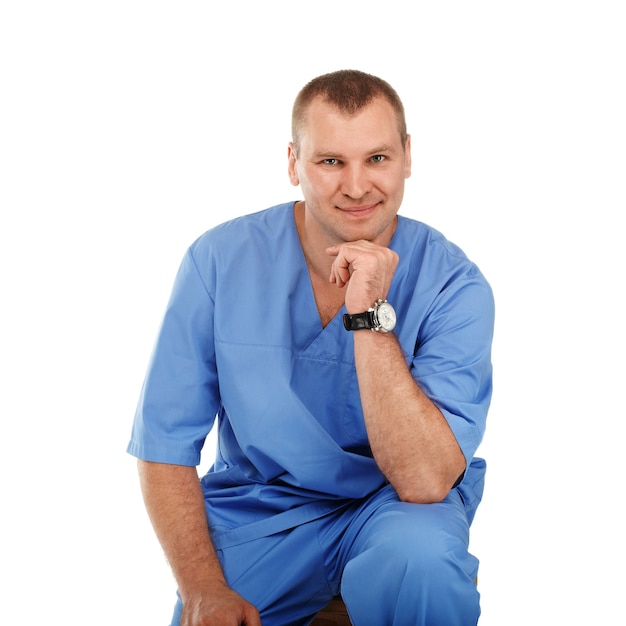 Portrait of a young male doctor in a medical surgical blue uniform against a white