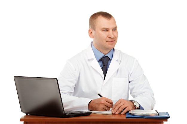 Portrait of a young male doctor in a white coat against a white