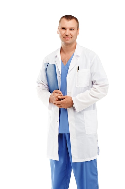 Portrait of a young male doctor in a white coat and blue scrubs against a white