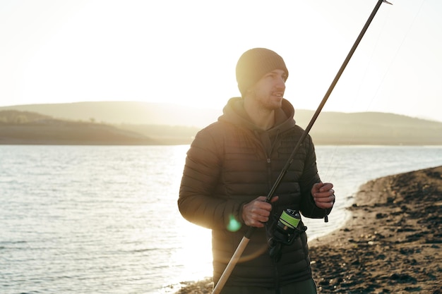 Portrait of a young male fisherman with fishing rod