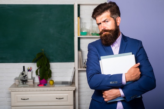 Portrait of young male teacher in school classroom. Tutor professor mentor man.