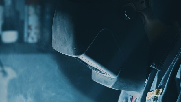 Portrait of a young male welder in a mask in the workshop