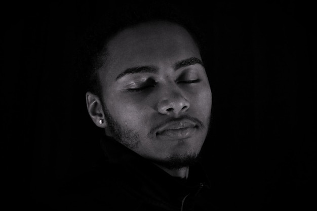 Photo portrait of young man against black background