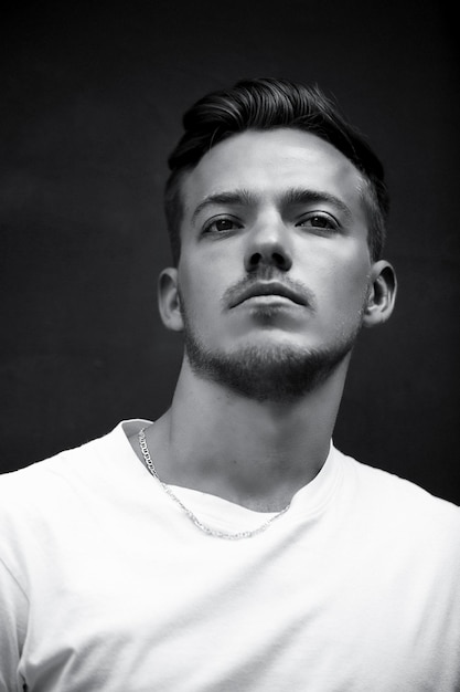 Portrait of young man against black background