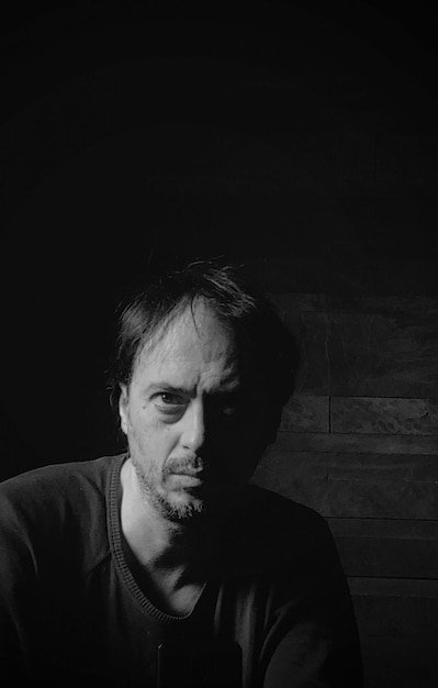 Photo portrait of young man against black background