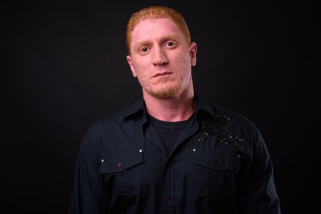 Photo portrait of young man against black background