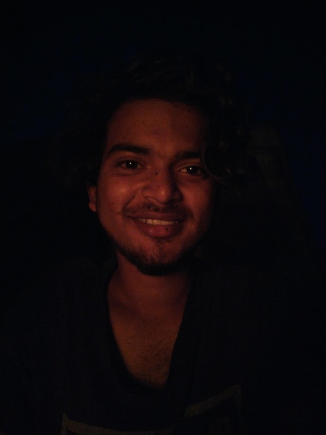 Photo portrait of young man against black background