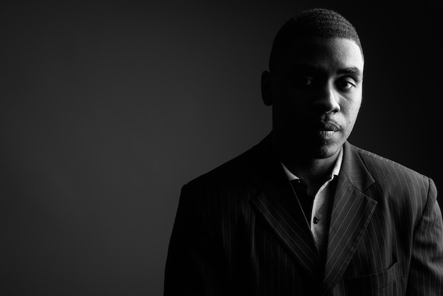 portrait of young man against black background