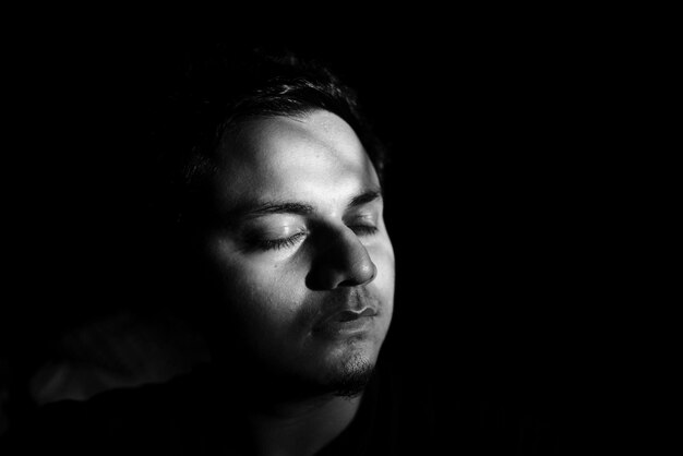 Portrait of young man against black background