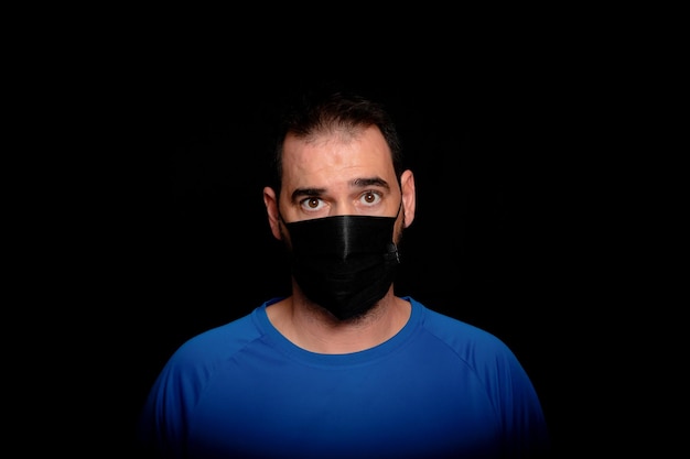 Portrait of young man against black background