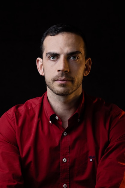 Photo portrait of young man against black background