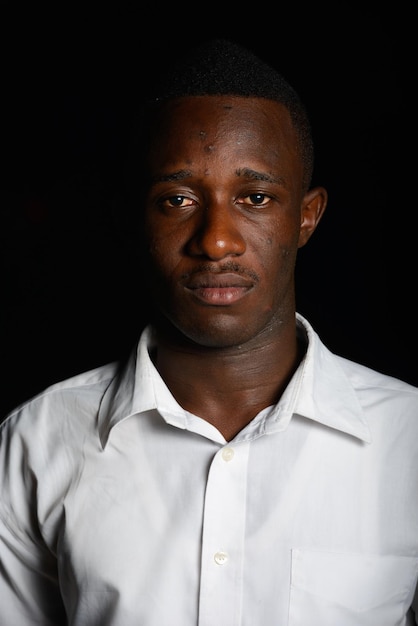 Photo portrait of young man against black background