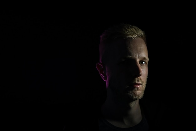 Photo portrait of young man against black background