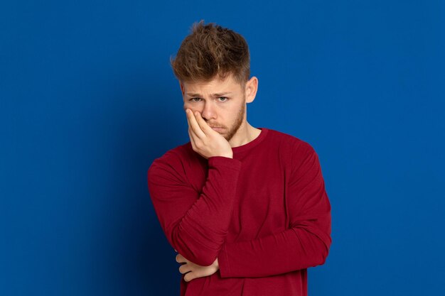 Portrait of young man against blue background