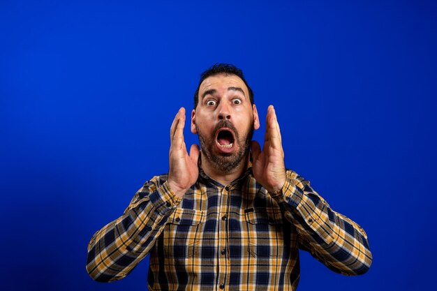 Portrait of young man against blue background