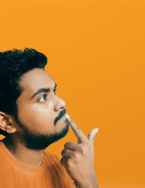 Portrait of young man against orange background