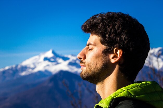 Portrait of young man against sky and mountain